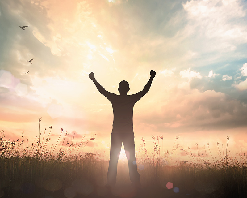 long_term_recovery_therapy Person standing in a field in the light representing long term recovery from addiction